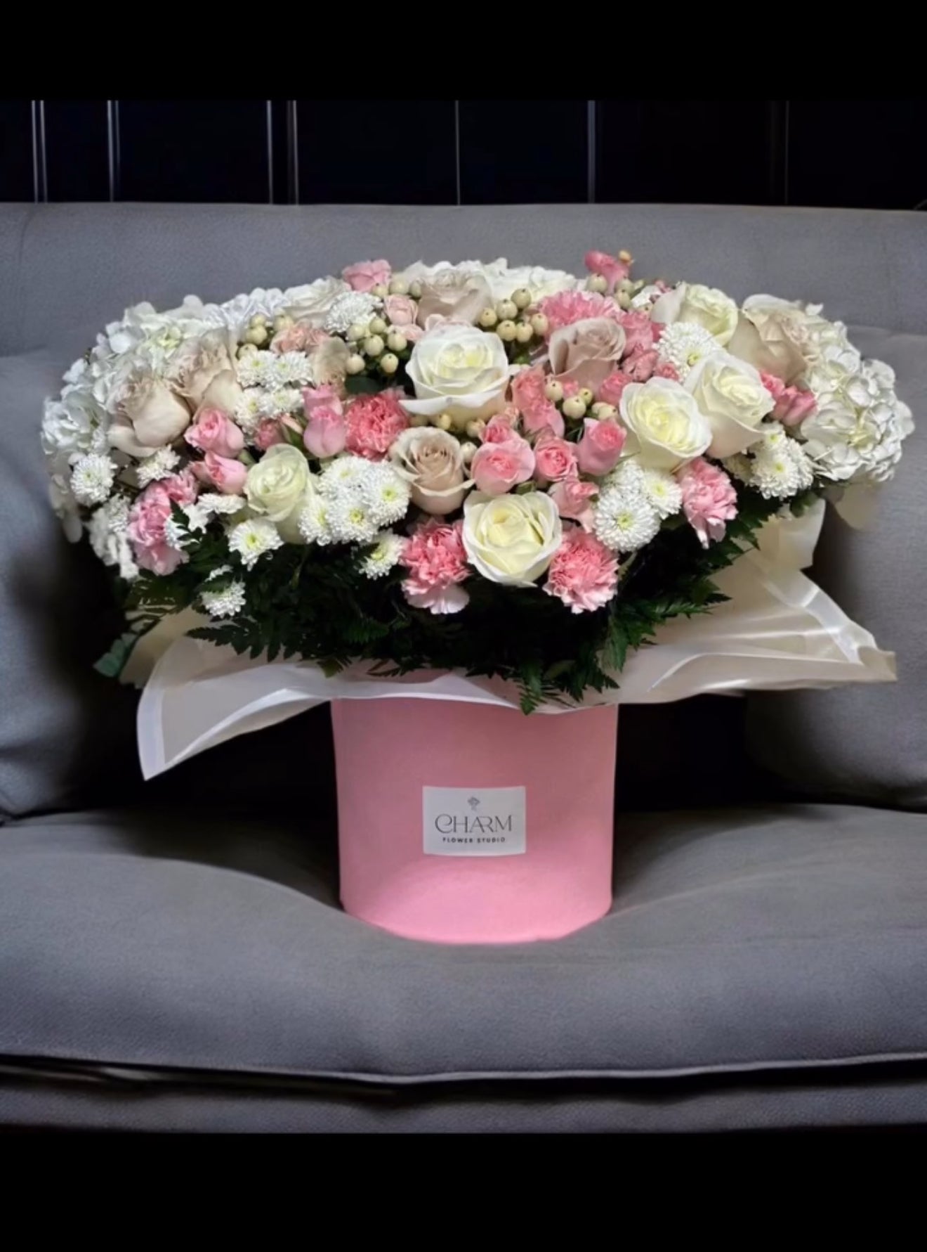 Elegant round box arrangement of pink and white roses, carnations, and lisianthus in a pink hatbox. Please note: flowers and wrapping may vary slightly to ensure freshness.